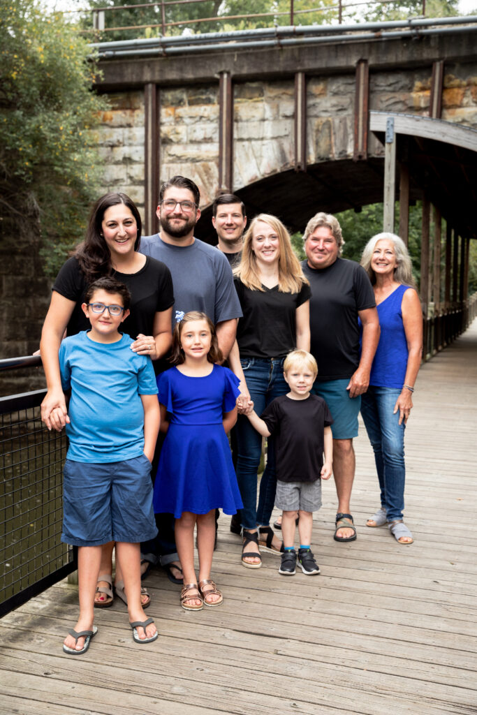 Extended family photo on boardwalk in front of bridge near river at Mill Creek Park in Dexter Michigan