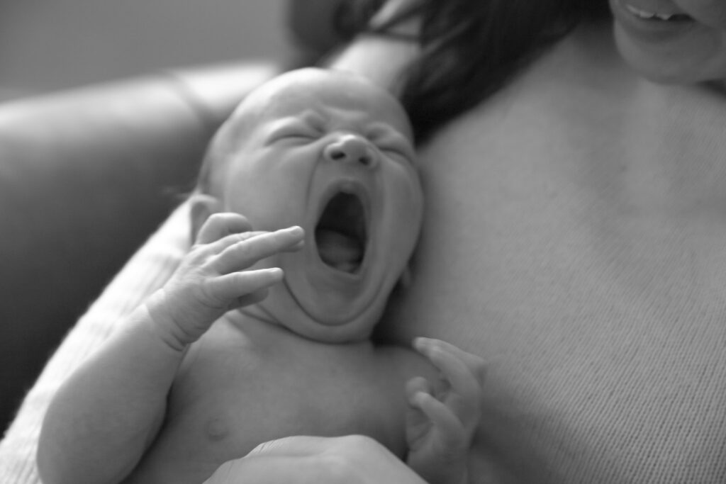 black and white photo of newborn baby yawning