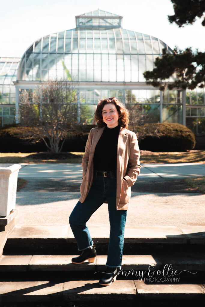 woman stands on steps outside belle isle conservatory in detroit michigan