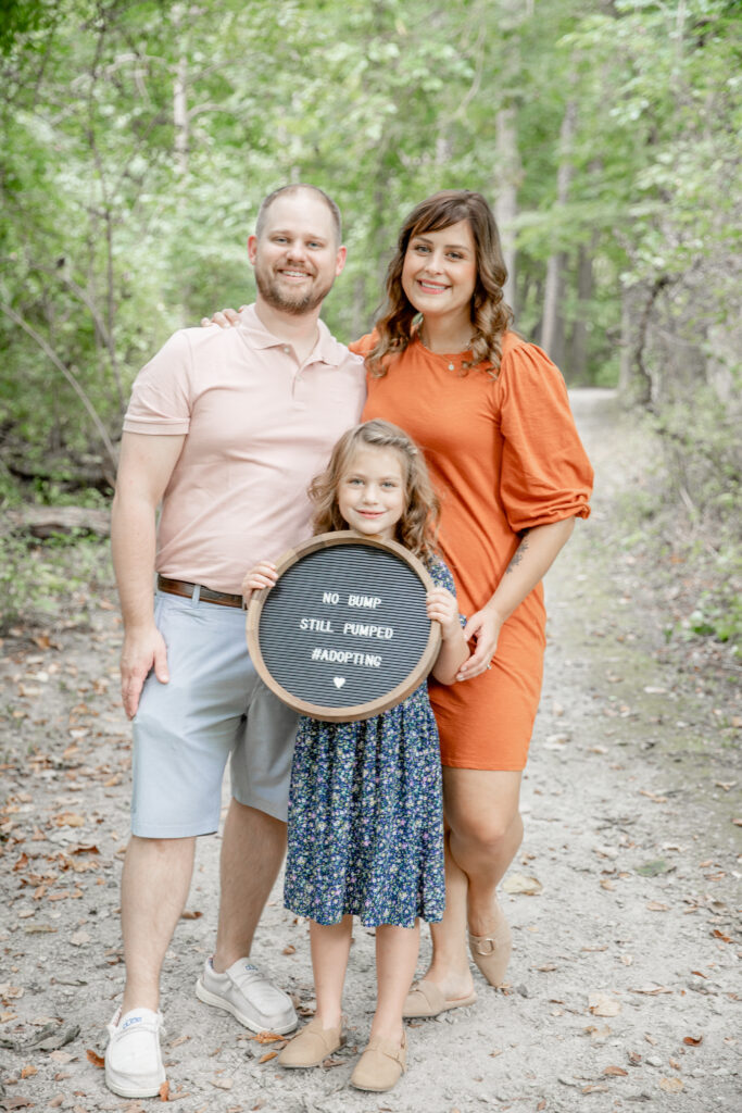 photo of family announcing adoption on path in woods