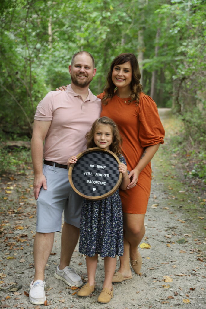 Raw photo of family announcing adoption on path in woods