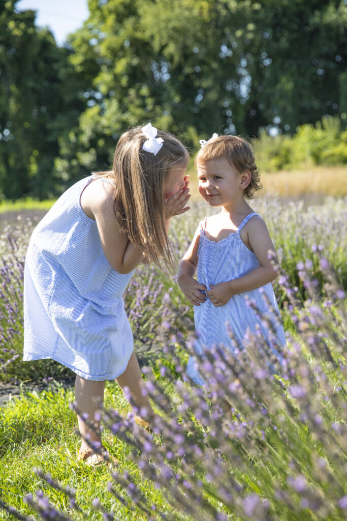 sisters whispering to each other in a lavender field