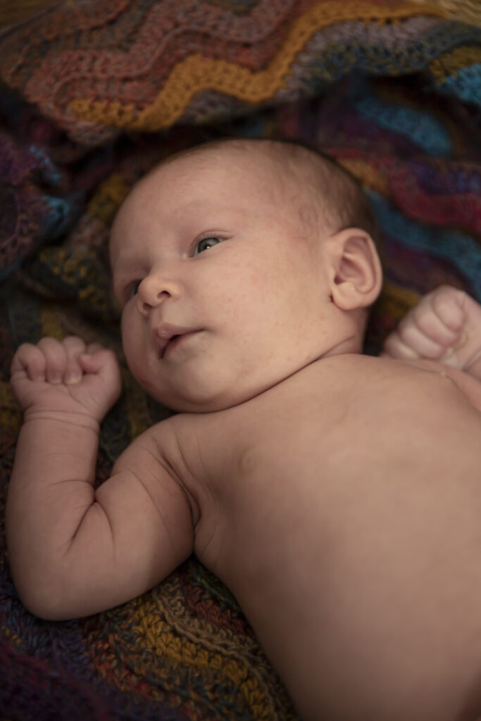 close up of newborn baby on beautiful crocheted blanket