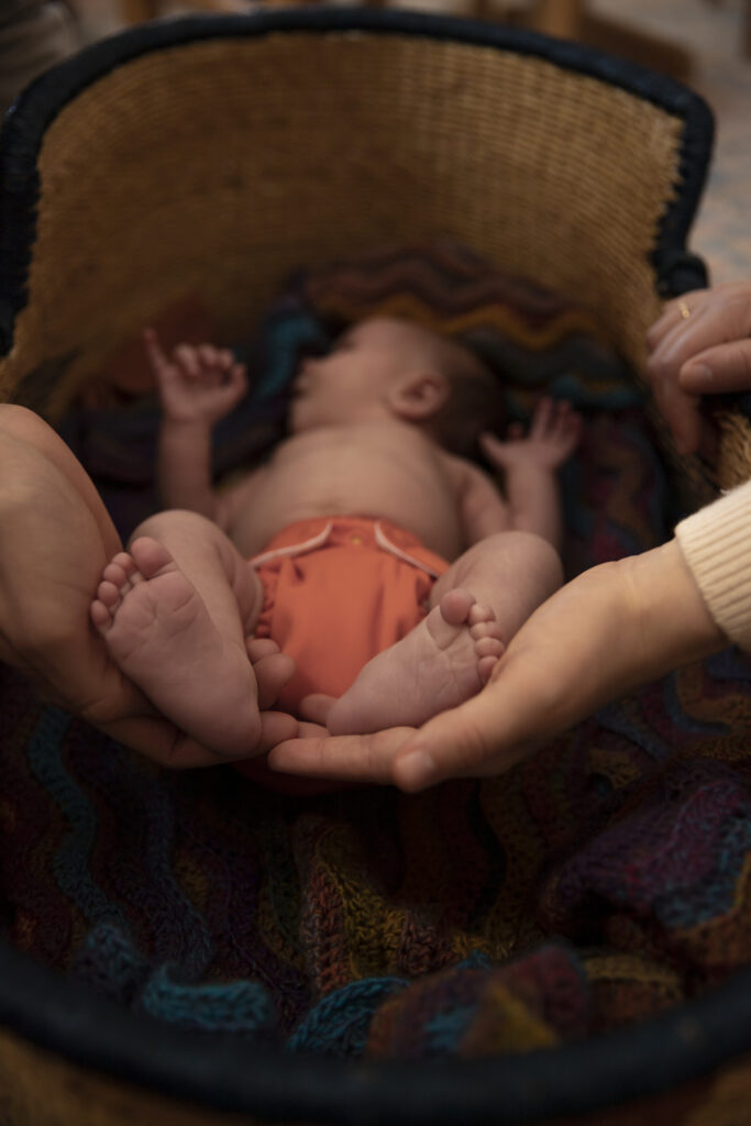 close up of father and mother cradling newborn's feet