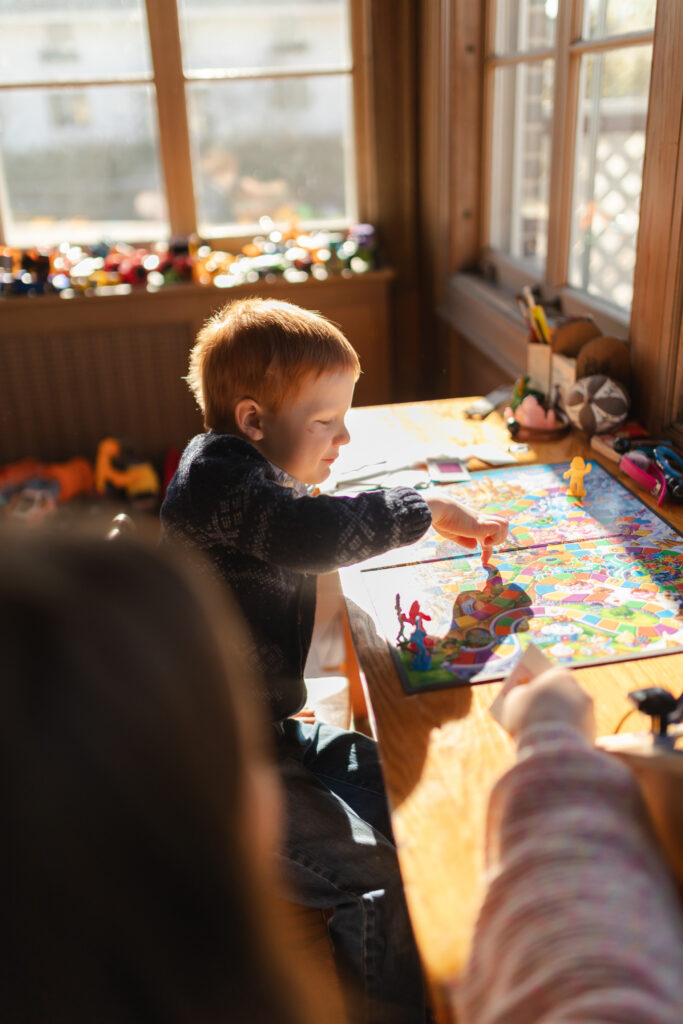 mother and young son play candyland in sunroom of their home in ann arbor michigan