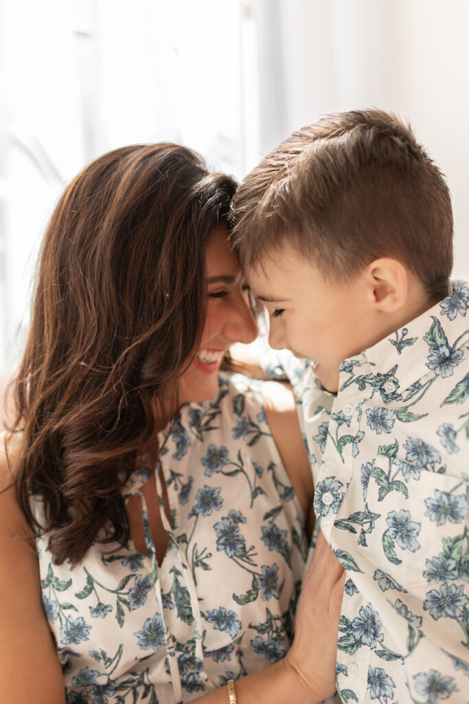 mother leans into young son's forehead while laughing together at motherhood session at studiostudio in ann arbor michigan