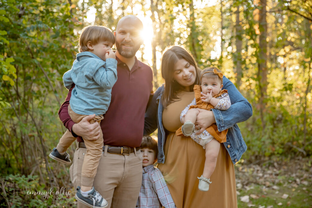 Family of 5 stand together during golden hour in the fall