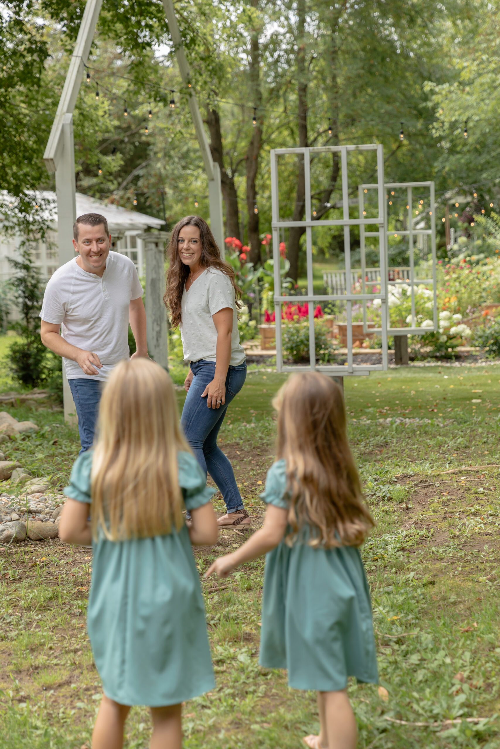 Family of four plays red light green light together in the garden at Rustic Wild Arrow in Brooklyn, Michigan