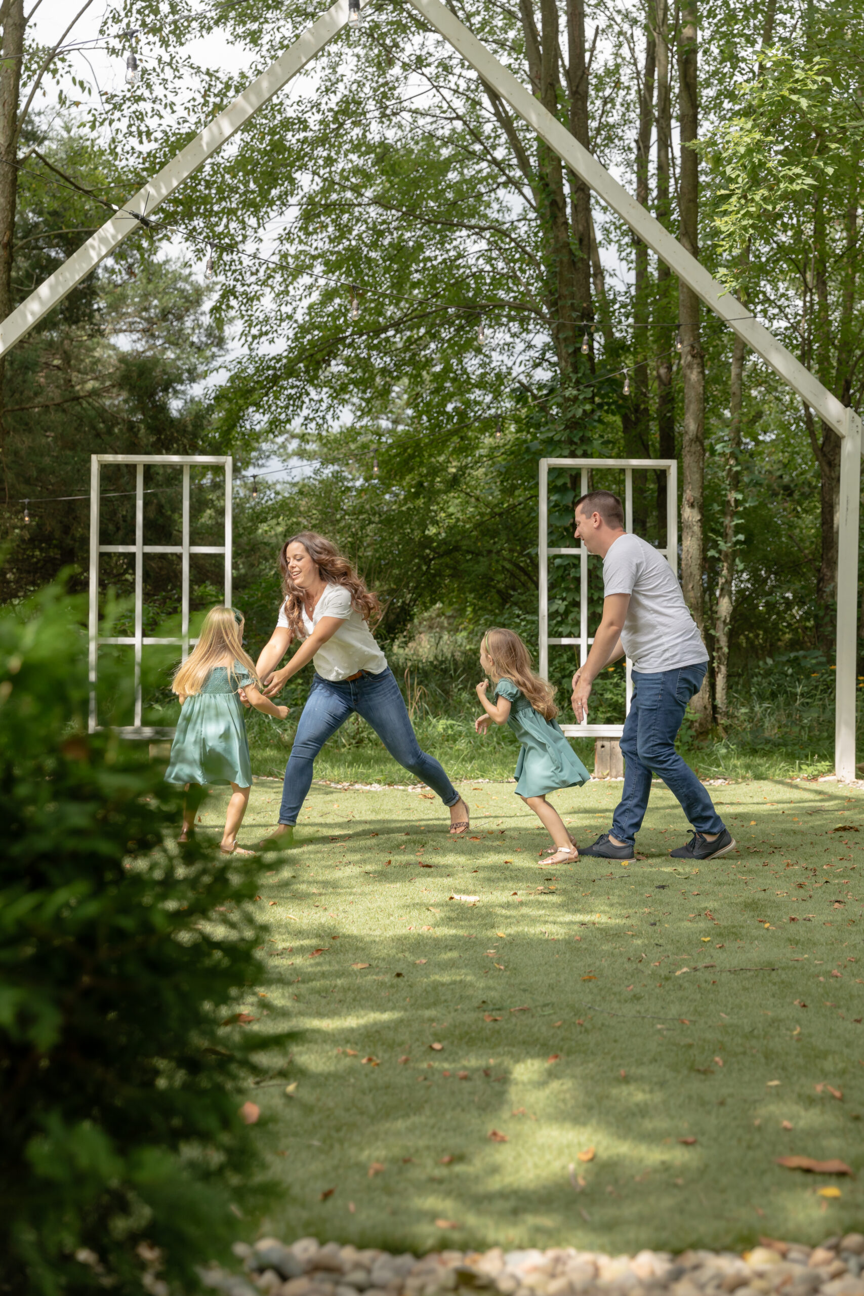 Family of four plays tag in the open air chapel at Rustic Wild Arrow in Brooklyn, Michigan