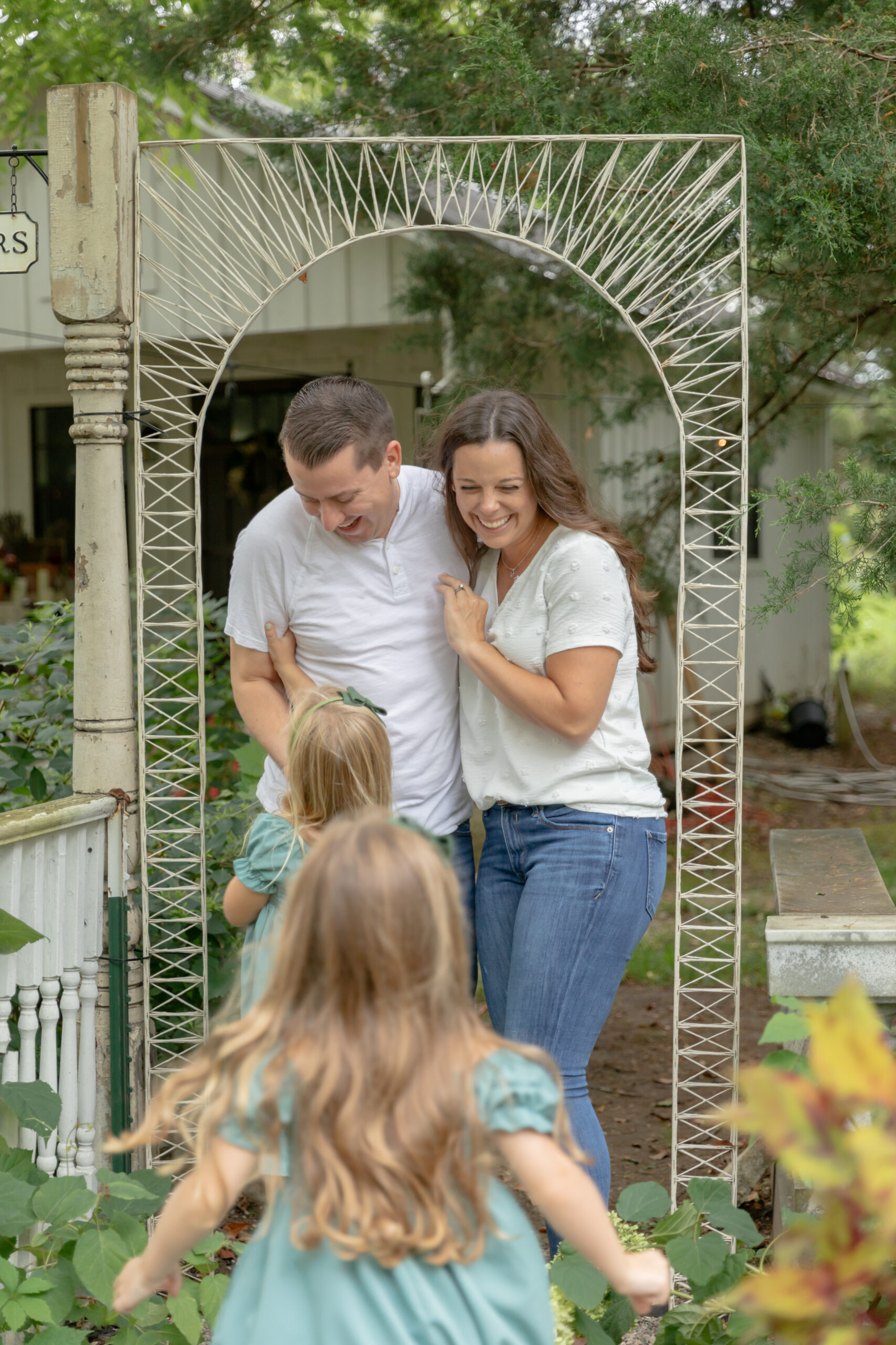 Young girls run up to their parents to tickle them in the garden of Rustic Wild Arrow in Brooklyn, Michigan