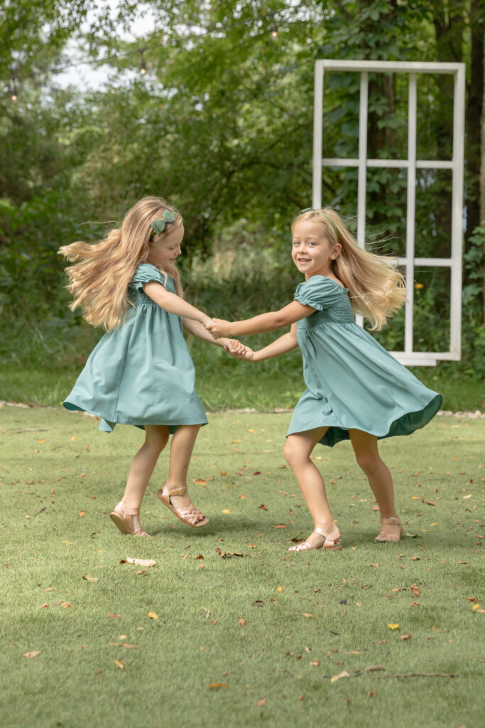 Young sisters play ring around the rosie in an open air chapel at Rustic Wild Arrow in Brooklyn, Michigan