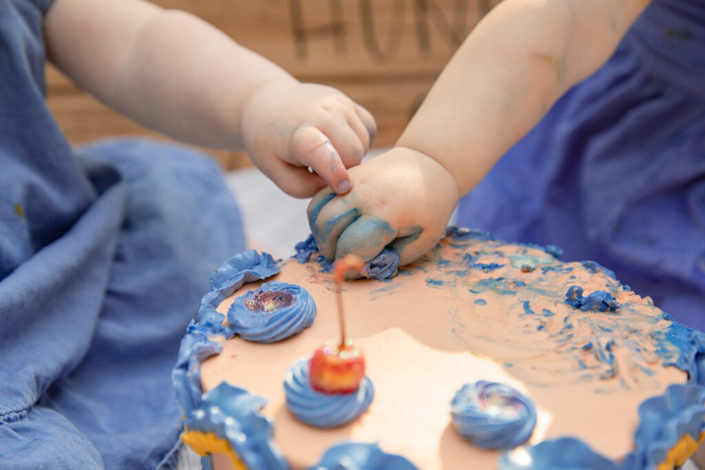 Close up of two baby girls' hands on a cake during a cake smash photo shoot