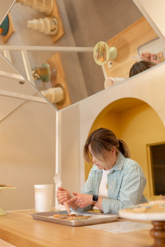 cookie decorating demonstration at sweet heather anne with mirror above demo for participants to see