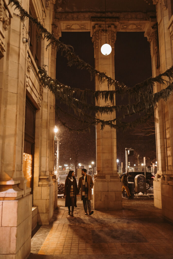 man and woman walk through nickels arcade entrance on blustery winter evening