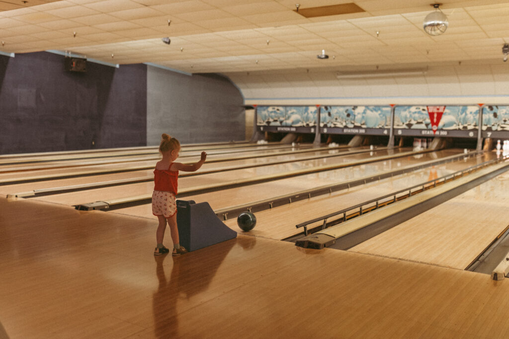 girl rolls bowling ball down ramp during bumper bowling at station 300 in saline michigan