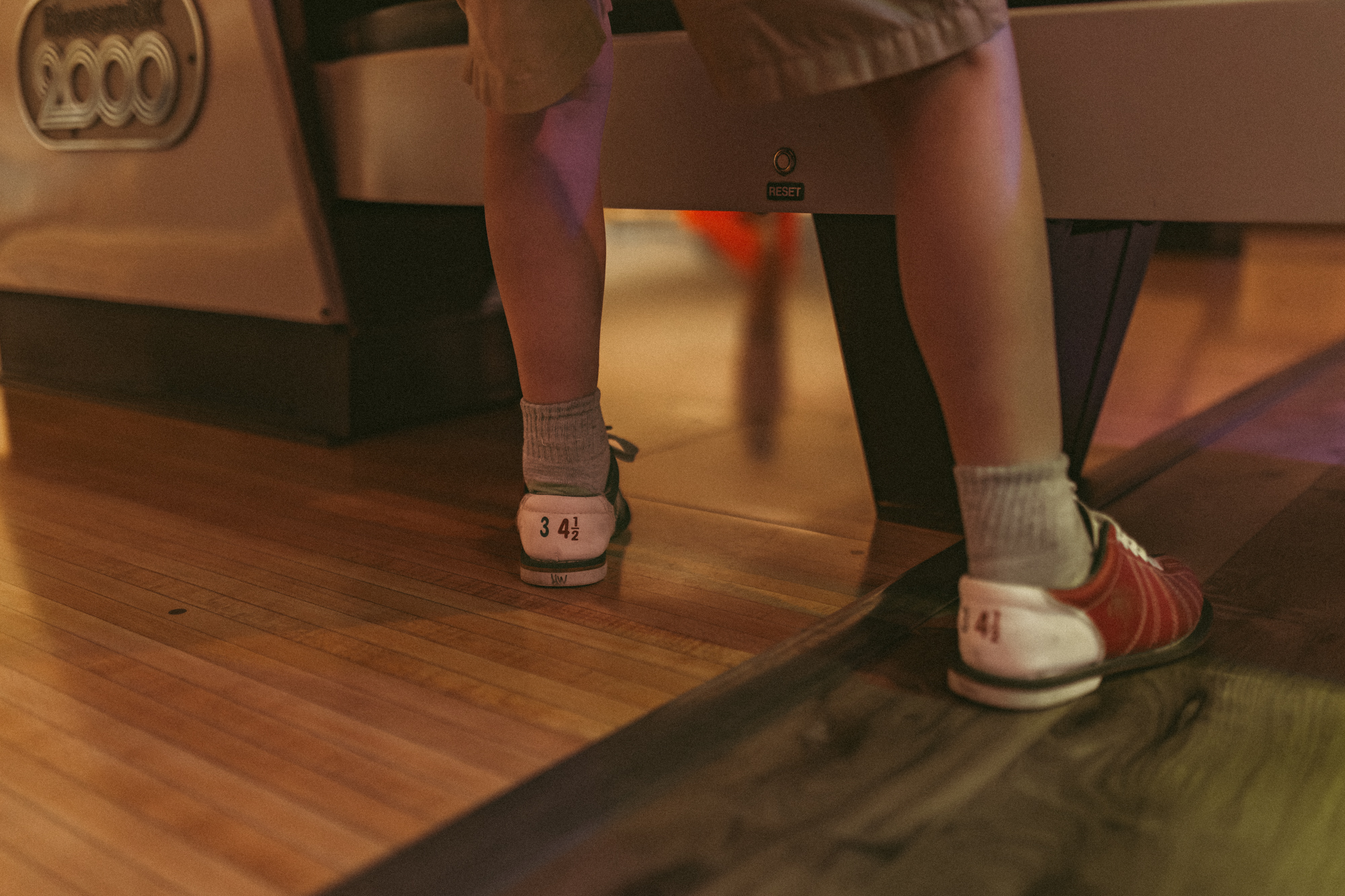 close photo of boy wearing vintage bowling shoes at station 300 in saline michigan